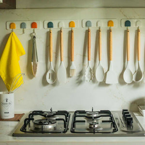 Cream spatula set hanging on kitchen wall 
